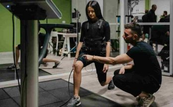 Ragazza in palestra prova l'allenamento con gli elettrodi