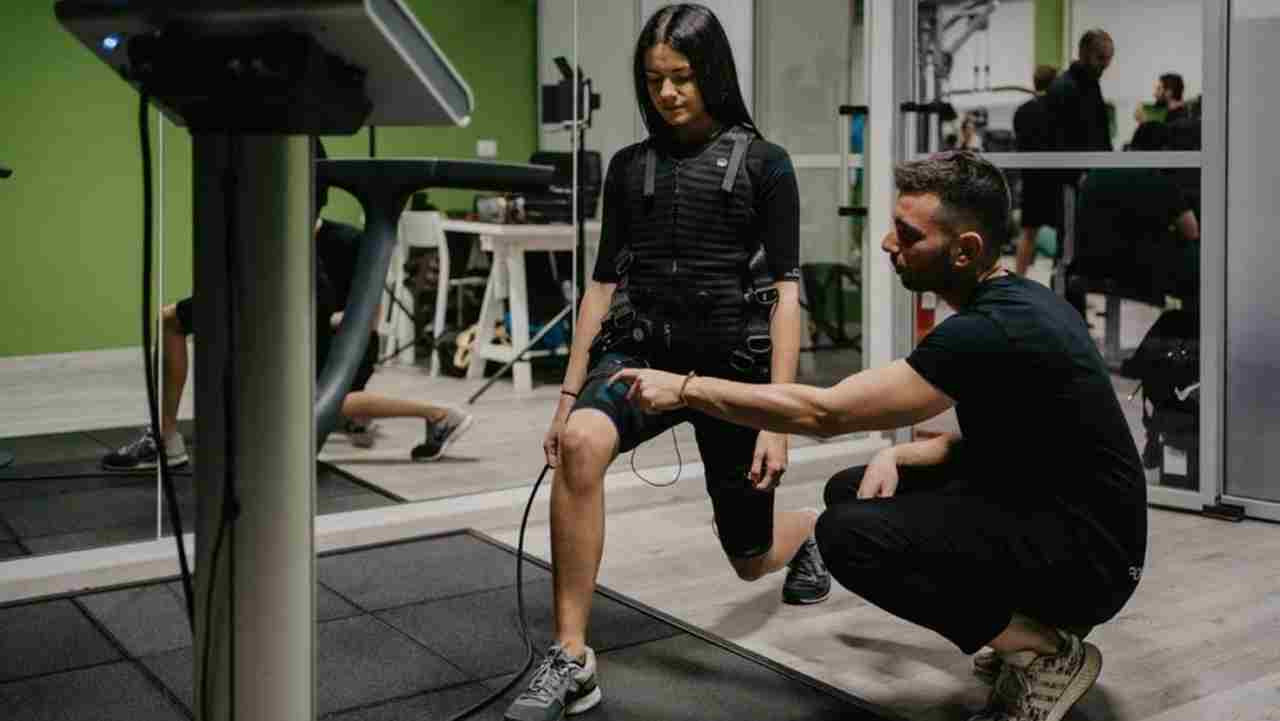 Ragazza in palestra prova l'allenamento con gli elettrodi