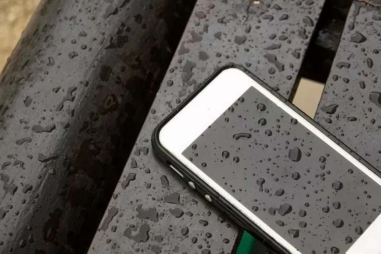 telefono iPhone bagnato sulla panchina dopo un forte acquazzone 