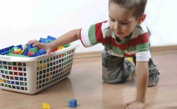 Bambino che prende mattoncini dalla cesta dei giocattoli