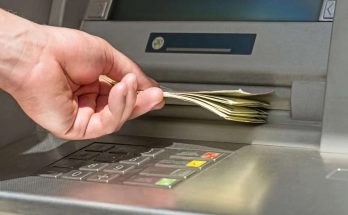 persona ritira i soldi dal bancomat