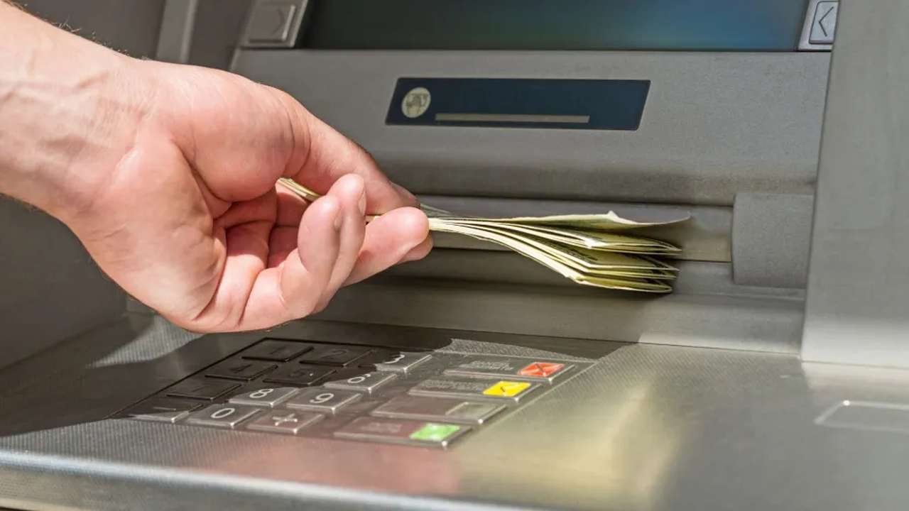 persona ritira i soldi dal bancomat