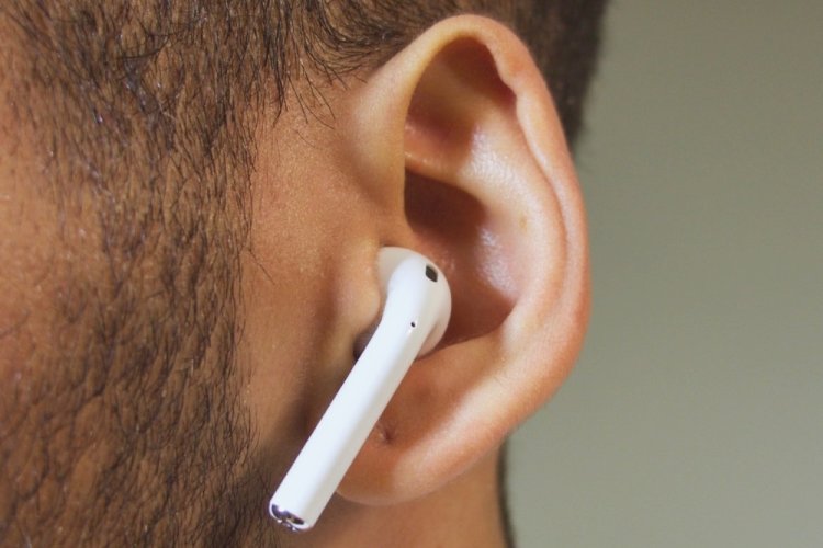 cuffiette in-ear o airpods nell'orecchio di un uomo