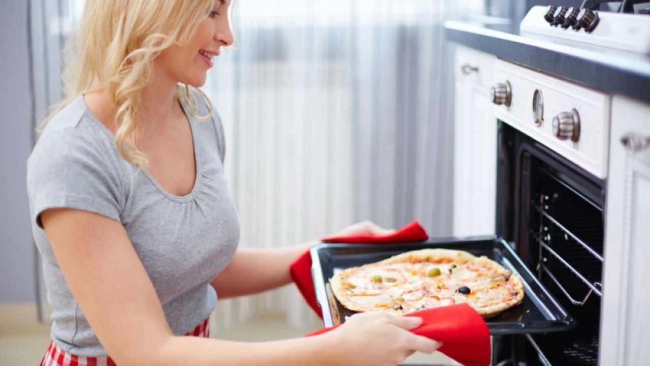 donna inforna pizza nel forno elletrico
