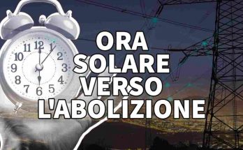 sveglia sulla mano con sfondo tralicci dell'elettricità